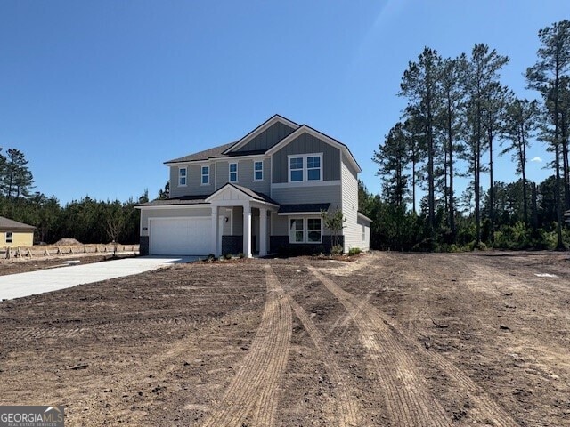 traditional home with concrete driveway, board and batten siding, and a garage