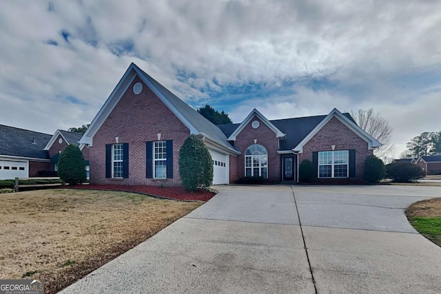 traditional home with a garage, brick siding, driveway, and a front lawn