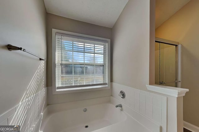 bathroom featuring a shower with shower door, a textured ceiling, and a bath