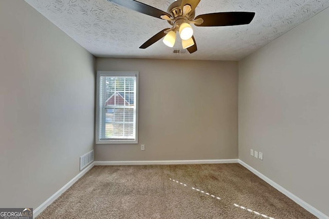 unfurnished room featuring carpet floors, visible vents, a ceiling fan, a textured ceiling, and baseboards