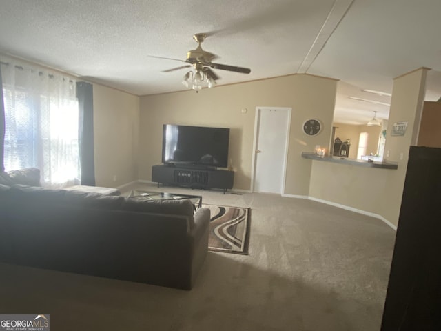 living room featuring a textured ceiling, carpet floors, a ceiling fan, baseboards, and vaulted ceiling