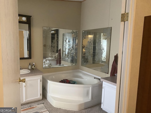 bathroom featuring a garden tub and vanity