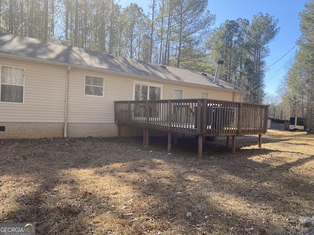 rear view of house featuring a wooden deck