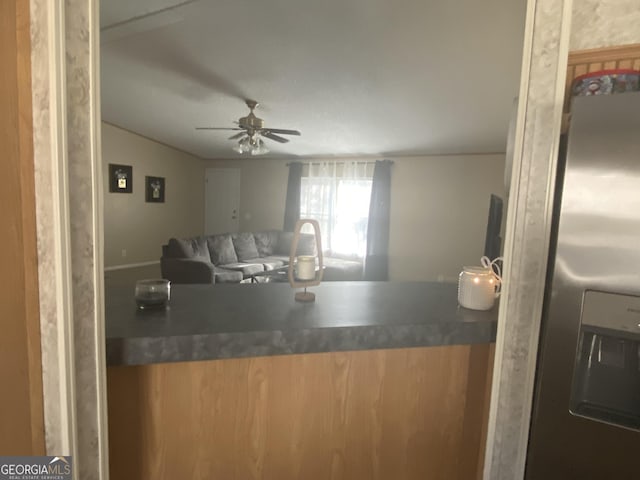 kitchen featuring open floor plan, ceiling fan, and stainless steel fridge with ice dispenser