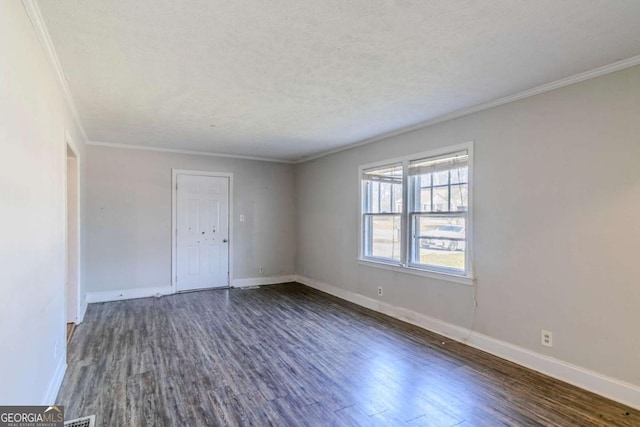 empty room featuring dark wood-style floors, crown molding, a textured ceiling, and baseboards