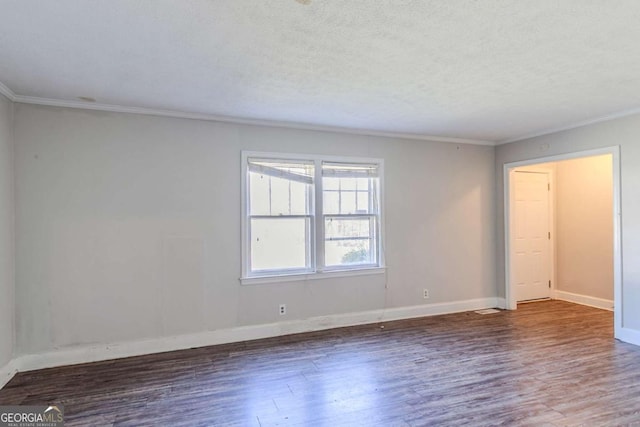 spare room featuring a textured ceiling, baseboards, wood finished floors, and crown molding