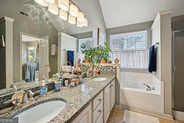 bathroom featuring lofted ceiling, a garden tub, double vanity, and a sink