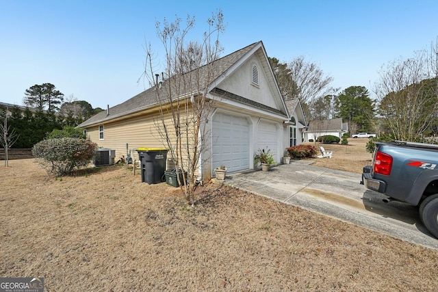 view of property exterior with concrete driveway, central AC, and an attached garage