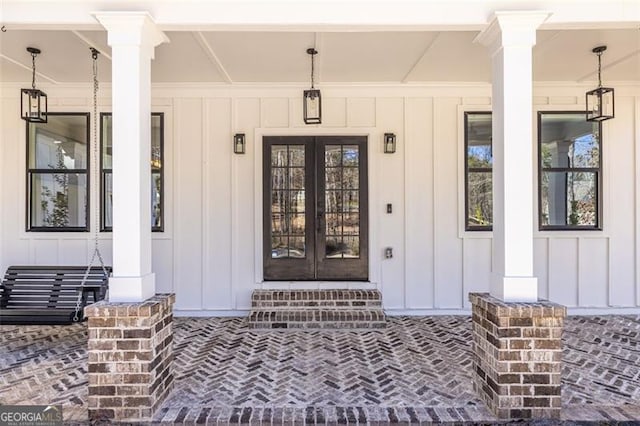 entrance to property featuring covered porch, french doors, and board and batten siding