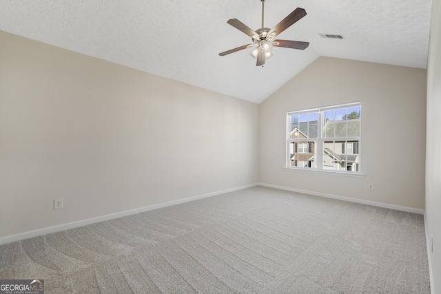 carpeted spare room with visible vents, vaulted ceiling, a textured ceiling, ceiling fan, and baseboards