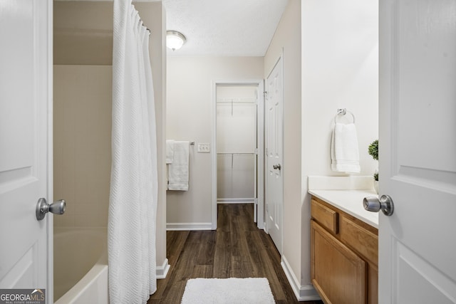 bathroom featuring vanity, a textured ceiling, baseboards, and wood finished floors