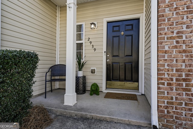 property entrance with covered porch and brick siding