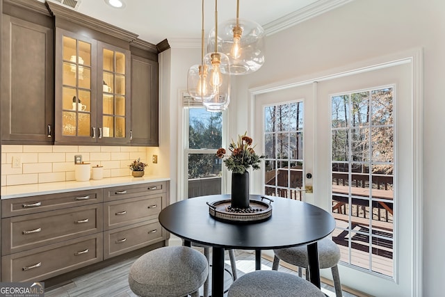 dining area featuring ornamental molding and wood finished floors