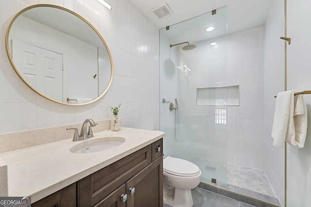 bathroom featuring visible vents, vanity, toilet, and a walk in shower