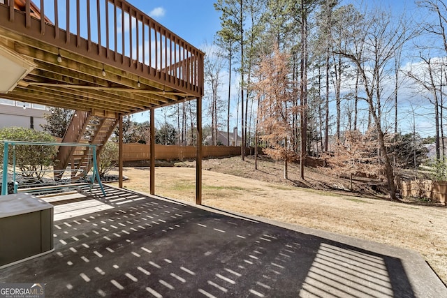 view of patio featuring stairs, fence, and a wooden deck