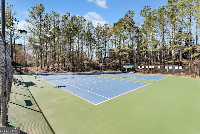 view of tennis court featuring fence