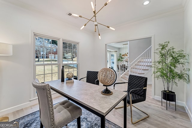 office space with ornamental molding, light wood-type flooring, and an inviting chandelier