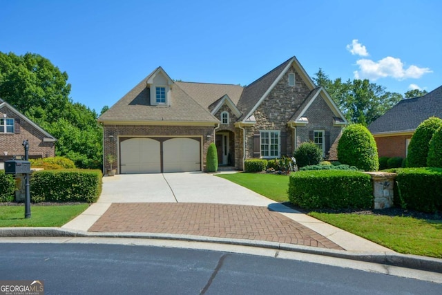 view of front facade featuring driveway, a garage, stone siding, a front lawn, and brick siding