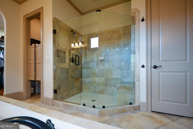 bathroom featuring a stall shower and a walk in closet