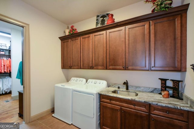 laundry room featuring cabinet space, a sink, baseboards, and separate washer and dryer