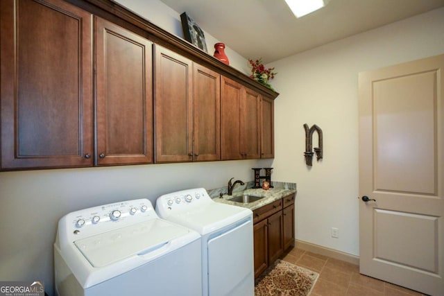 washroom featuring independent washer and dryer, a sink, cabinet space, and baseboards