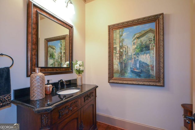 bathroom featuring wood finished floors, vanity, and baseboards