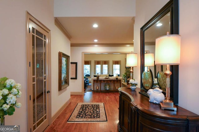 corridor featuring french doors, crown molding, recessed lighting, light wood-style flooring, and baseboards