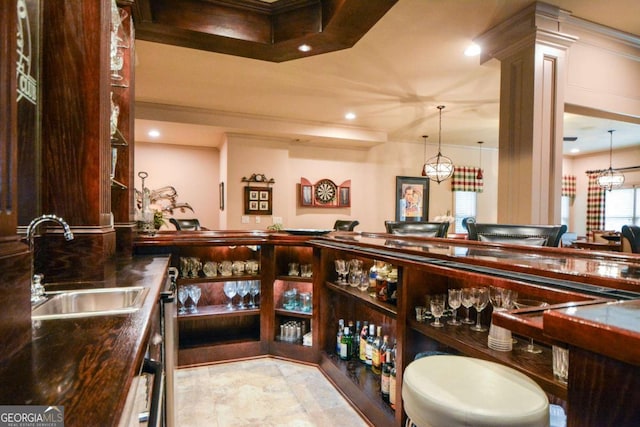 wine area with crown molding, recessed lighting, a sink, and ornate columns