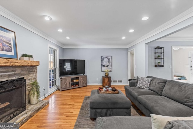 living room with recessed lighting, a fireplace, baseboards, light wood-style floors, and ornamental molding