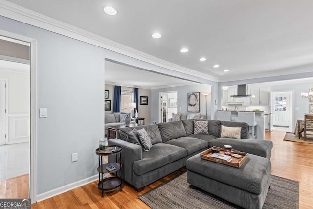 living area featuring light wood-style flooring, a chandelier, crown molding, and recessed lighting