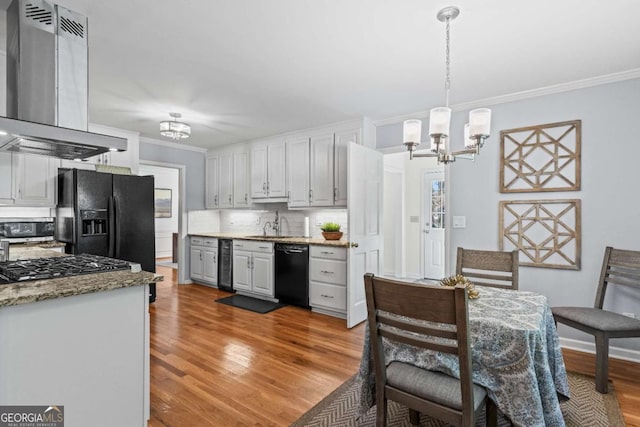 kitchen featuring ornamental molding, a notable chandelier, black appliances, and exhaust hood