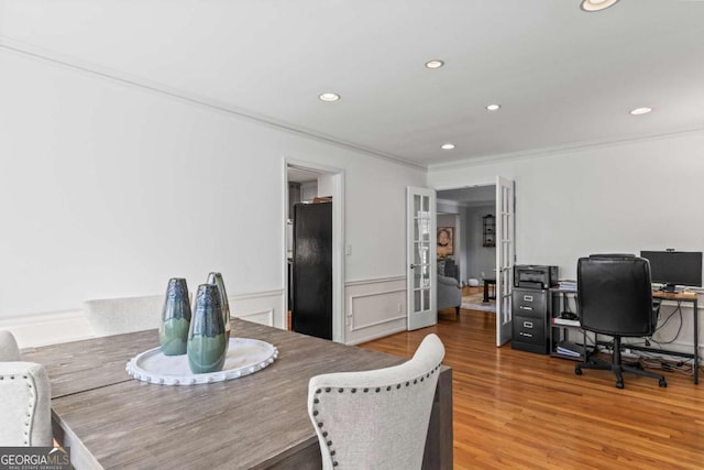 dining room with a wainscoted wall, wood finished floors, crown molding, french doors, and recessed lighting