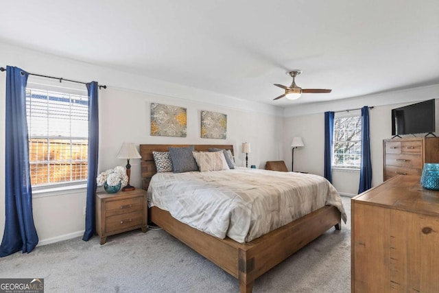 bedroom with light carpet, ceiling fan, and baseboards