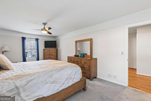 carpeted bedroom featuring baseboards, visible vents, and a ceiling fan