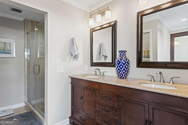 bathroom with a stall shower, ornamental molding, and a sink