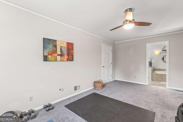 exercise area featuring ceiling fan, carpet floors, ornamental molding, and baseboards