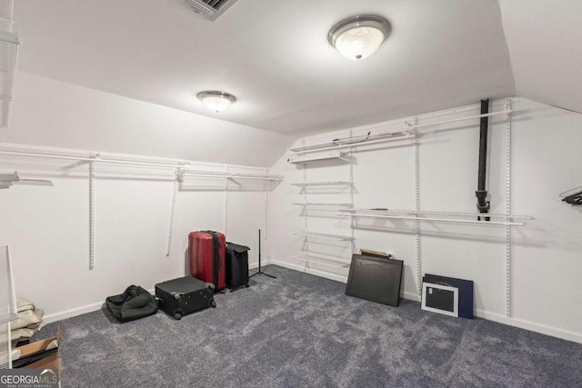 walk in closet featuring visible vents, vaulted ceiling, and carpet flooring