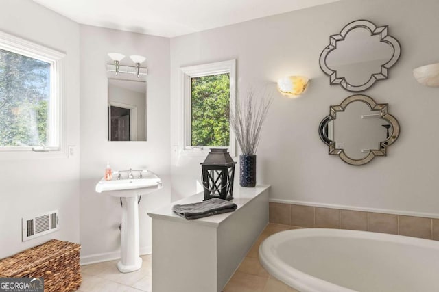 bathroom with tile patterned flooring, visible vents, and a bath