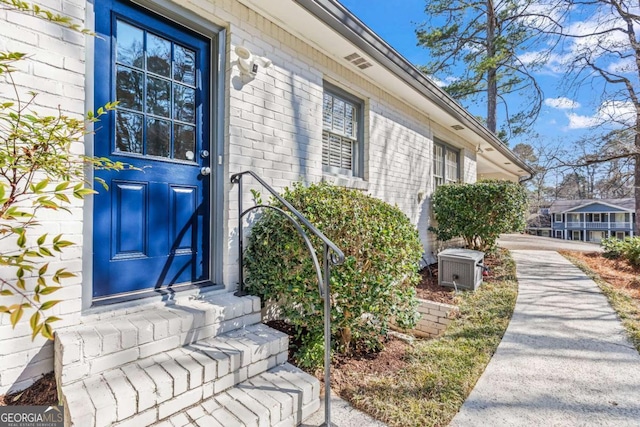 view of exterior entry with brick siding