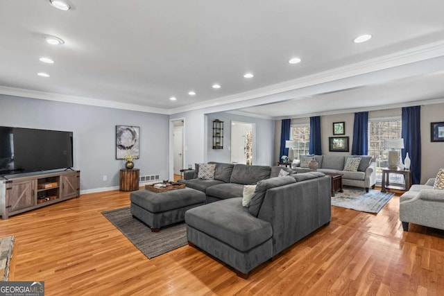 living room featuring light wood-style floors, visible vents, crown molding, and baseboards