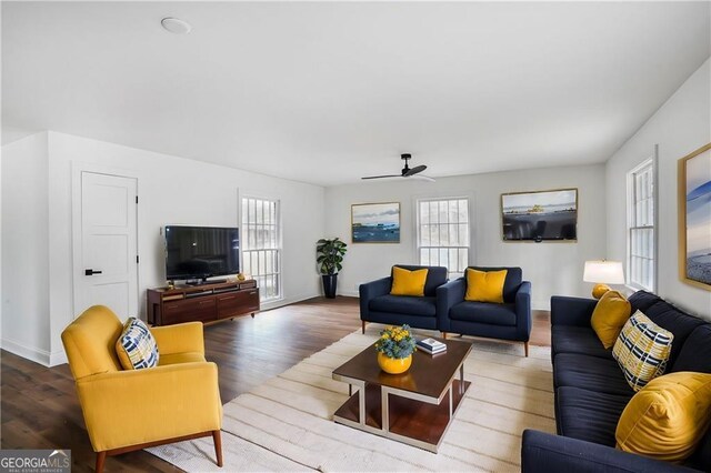 living area with ceiling fan, a wealth of natural light, and wood finished floors