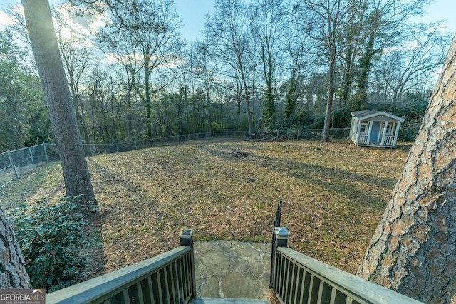 view of yard with a fenced backyard, an outdoor structure, and a shed