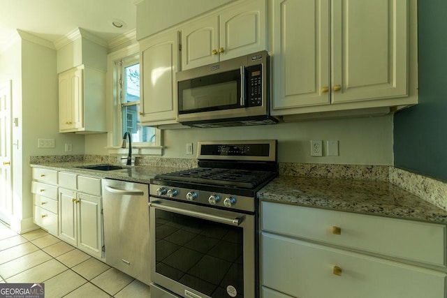 kitchen with appliances with stainless steel finishes, a sink, light stone counters, and crown molding