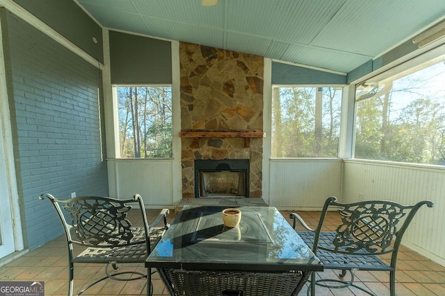 sunroom featuring lofted ceiling and a fireplace