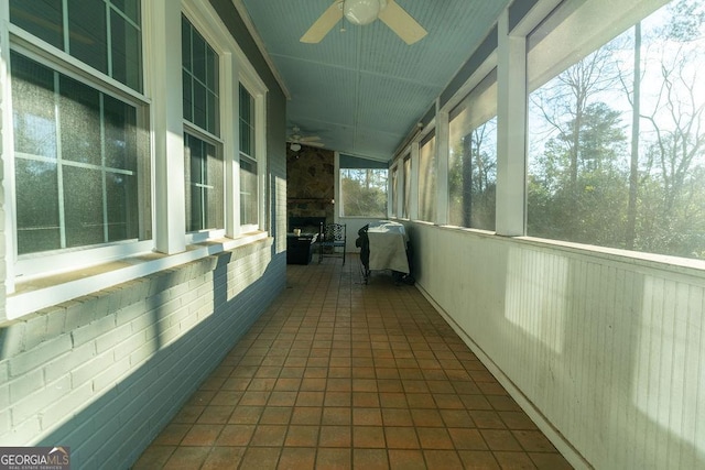 unfurnished sunroom featuring ceiling fan