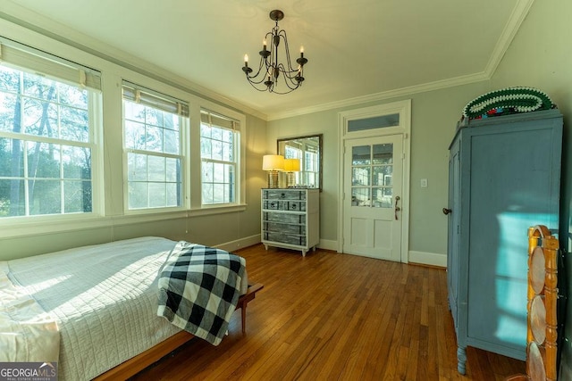 bedroom featuring ornamental molding, a chandelier, baseboards, and wood finished floors