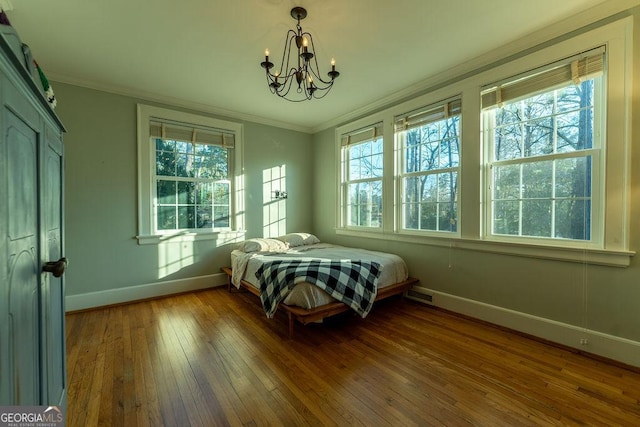 bedroom with wood-type flooring, multiple windows, and crown molding