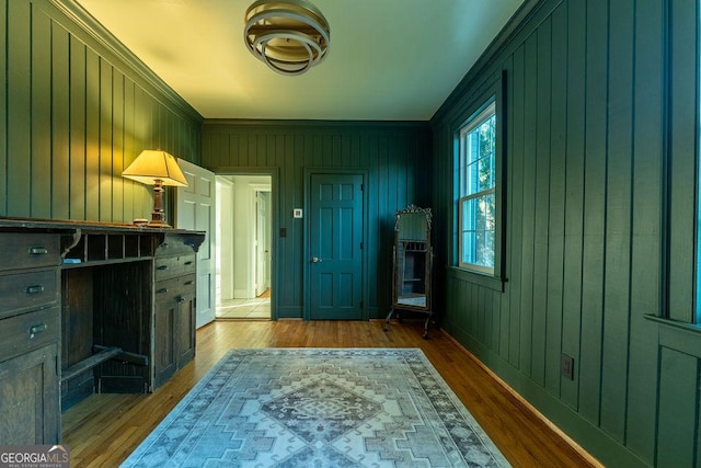 interior space featuring wood finished floors and crown molding