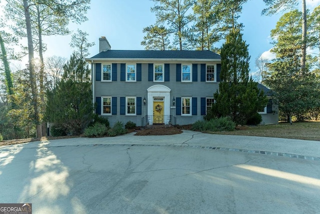 colonial inspired home featuring a chimney