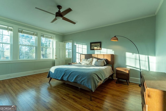 bedroom featuring dark wood-style floors, ornamental molding, and baseboards